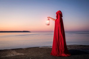Caucasian woman with lantern overlooking ocean